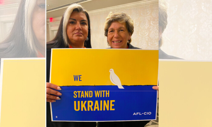 La presidente de AFT, Randi Weingarten, y la vicepresidenta ejecutiva, Evelyn DeJesus, posan con un cartel que colocaba por error los colores nacionales de Ucrania al revés. (Twitter)
