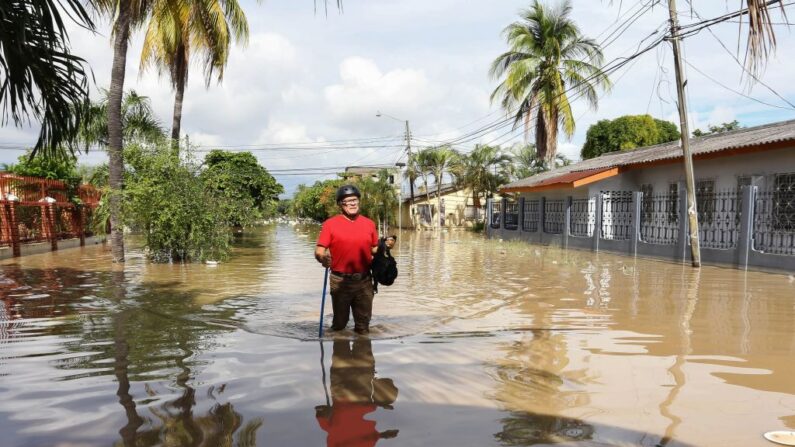 Un hombre camina por el agua en el municipio inundado de La Lima, cerca de San Pedro Sula, en Honduras, el 19 de noviembre de 2020, después de que las fuertes lluvias del huracán Iota provocaran el desbordamiento del río Chamelecón. (Wendell Escoto/AFP vía Getty Images)