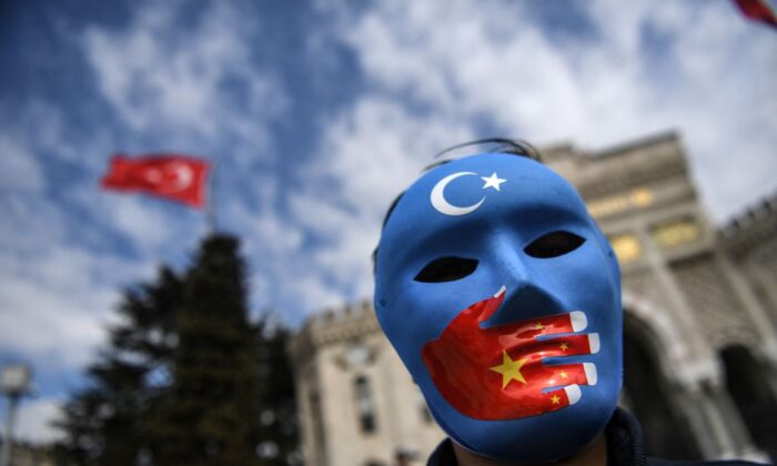 Un manifestante, con una máscara pintada con los colores de la bandera de Turkestán Oriental, participa en una protesta uigur en la plaza Beyazid de Estambul, el 1 de abril de 2021. (Ozan Kose/AFP vía Getty Images)
