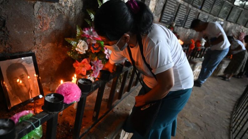 Personas participan en una procesión de velas que culmina con una ofrenda de luz a las víctimas de la masacre de El Mozote durante la conmemoración de su 40 aniversario en El Mozote, a 200 km al este de San Salvador, el 11 de diciembre de 2021.  (MARVIN RECINOS/AFP vía Getty Images)