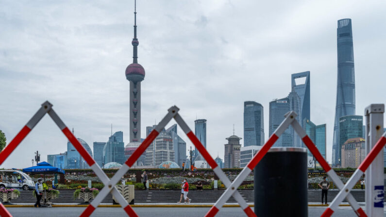 Los peatones caminan por el Bund frente al Centro Financiero de Lujiazui en Shanghái, China, el 10 de junio de 2022, en medio de los preparativos para las pruebas de COVID-19 en toda la ciudad. (Liu Jin/AFP vía Getty Images)
