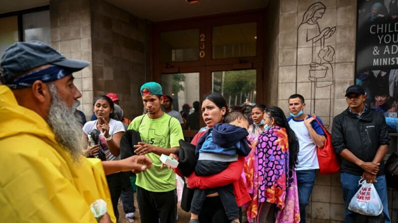 Reinaldo Calderón (izq.) distribuye artículos de primera necesidad a los inmigrantes mientras esperan fuera de una casa de acogida en San Antonio, Texas, el 28 de junio de 2022.(CHANDAN KHANNA/AFP vía Getty Images)
