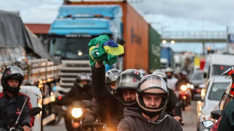 Simpatizantes del presidente Jair Bolsonaro, principalmente camioneros, bloquean la carretera BR-101 en Palhoca, en la región metropolitana de Florianópolis, estado de Santa Catarina, Brasil, el 31 de octubre de 2022, como aparente protesta por la derrota de Bolsonaro en la segunda vuelta de las elecciones presidenciales.  (ANDERSON COELHO/AFP vía Getty Images)