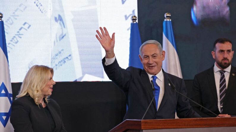 El exprimer ministro de Israel y líder del partido Likud, Benjamin Netanyahu, se dirige a sus partidarios, flanqueado por su esposa Sara, en la sede de la campaña en Jerusalén a primera hora del 2 de noviembre de 2022, tras el final de la votación para las elecciones nacionales. (MENAHEM KAHANA/AFP vía Getty Images)
