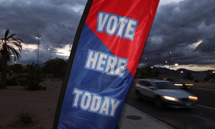 Un cartel con la leyenda "Vote Here Today" (Vote aquí hoy) se balancea al viento fuera de un colegio electoral al atardecer en la víspera de las elecciones de medio período en Estados Unidos, en Las Vegas, Nevada, el 7 de noviembre de 2022. (Ronda Churchill/AFP vía Getty Images)