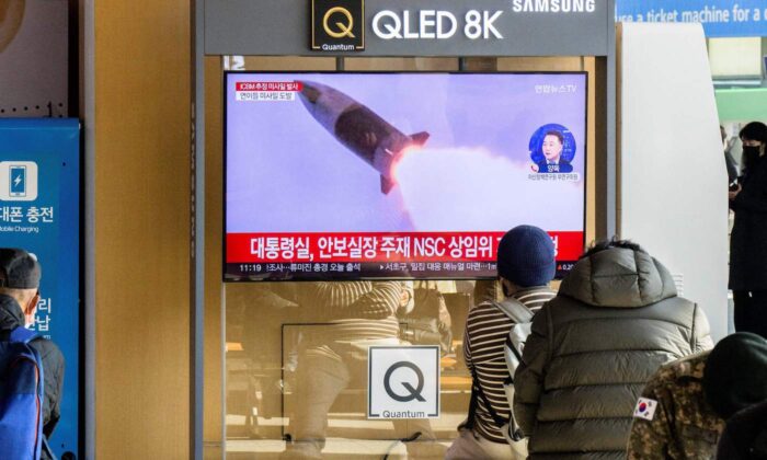Unas personas se sientan cerca de un televisor que muestra un noticiero con imágenes de archivo de una prueba de misiles de Corea del Norte, en una estación de tren en Seúl el 18 de noviembre de 2022. (Anthony Wallace/AFP vía Getty Images)