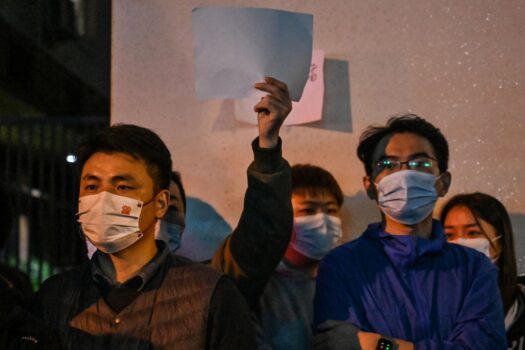 La gente muestra papeles en blanco como una forma de protestar en una calle de Shanghái el 27 de noviembre de 2022, donde la noche anterior se llevaron a cabo manifestaciones contra la política de cero COVID luego de un incendio mortal en Urumqi, la capital de la región de Xinjiang. (Héctor Retamal/AFP vía Getty Images)