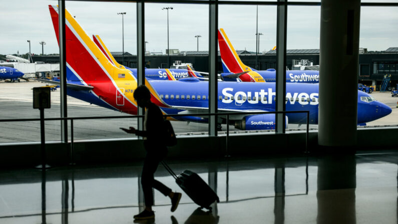 Un viajero pasa por delante de un avión de Southwest Airlines mientras sale de una puerta de embarque en el Aeropuerto Internacional Thurgood Marshall de Baltimore, Maryland, el 11 de octubre de 2021. (Kevin Dietsch/Getty Images)
