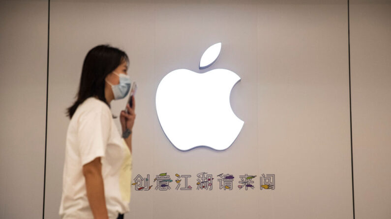 La gente lleva una mascarilla mientras pasa por el tablero del logotipo de la nueva tienda de Apple el 11 de abril de 2022 en Wuhan, provincia de Hubei, China. (Getty Images)