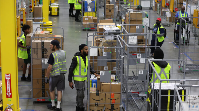 Trabajadores de Amazon mueven carros llenos de paquetes en una estación de entrega de Amazon el 28 de noviembre de 2022 en Alpharetta, Georgia (EE.UU.). (Justin Sullivan/Getty Images)