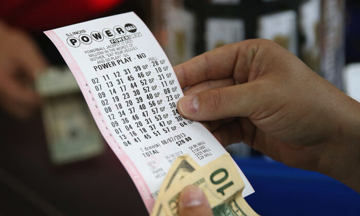 Un cliente de una tienda 7-Eleven verifica los números de su billete de lotería Powerball, en Chicago, Illinois, el 7 de agosto de 2013. (Scott Olson/Getty Images)
