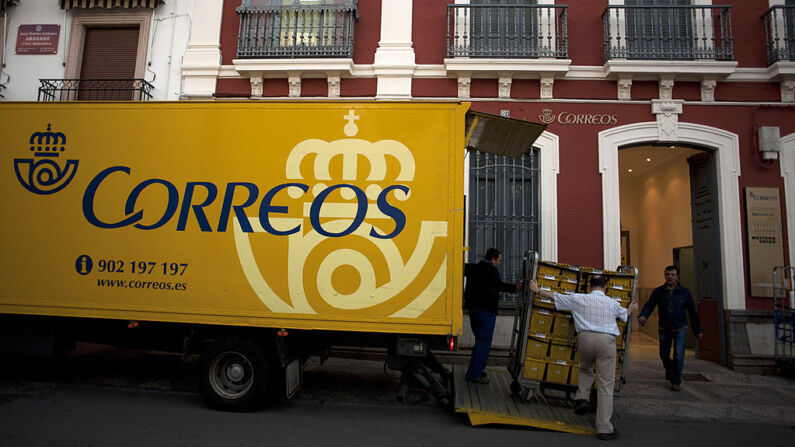 Empleados del servicio postal español cargan un camión con correo y paquetes en un camión en la oficina de clasificación de Ronda el 2 de octubre de 2013, en Ronda. (Jorge Guerrero/AFP vía Getty Images)