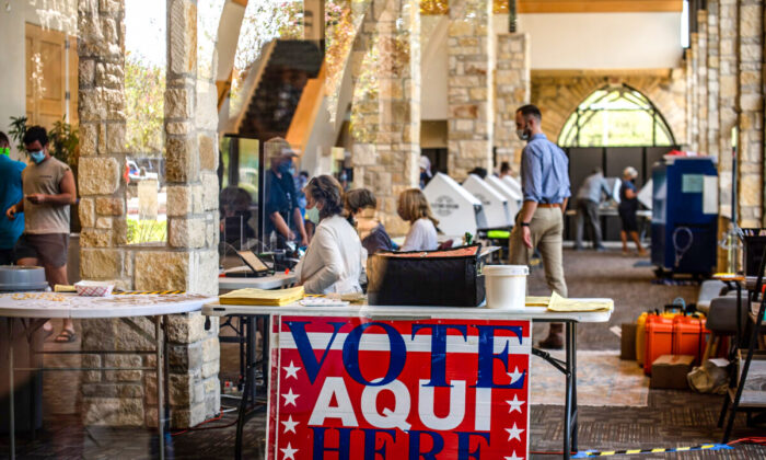 Los trabajadores electorales ayudan a los votantes dentro de un centro de votación en Austin, Texas, el 13 de octubre de 2020. (Sergio Flores/Getty Images)