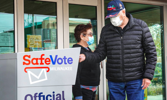 Los residentes depositan los votos por correo en una urna fuera de la biblioteca de la sucursal de Tippecanoe en Milwaukee, Wisconsin, el 20 de octubre de 2020. (Scott Olson/Getty Images)
