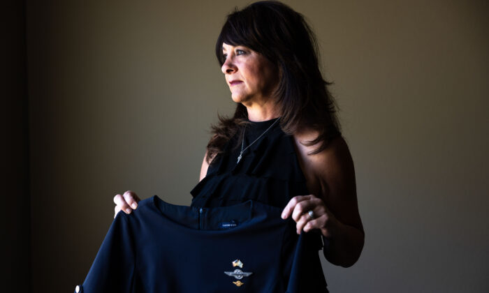 Charlene Carter, que trabajó para Southwest Airlines como azafata durante 21 años antes de ser despedida, sostiene su antiguo uniforme de azafata de Southwest Airlines en su casa de Aurora, Colorado, el 30 de agosto de 2022. (Michael Ciaglo para The Epoch Times)