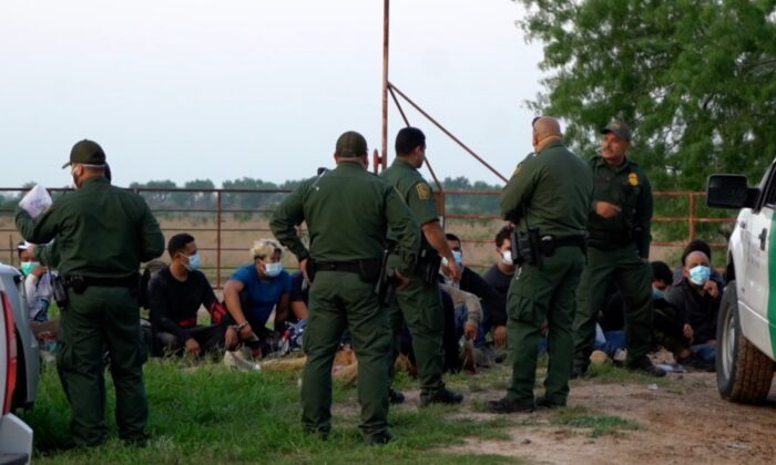 En una captura de imagen de vídeo publicado por NTD, agentes de la Patrulla Fronteriza detienen a inmigrantes ilegales en McAllen, Texas. (Sunny Yang/NTD)