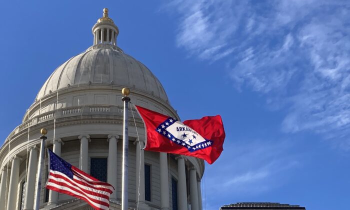 La bandera del estado de Arkansas y la de Estados Unidos ondean frente al Capitolio del Estado en Little Rock el 1 de diciembre de 2022. (Janice Hisle/The Epoch Times)