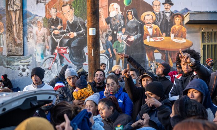 Inmigrantes ilegales reciben ropa donada afuera de un refugio en la Iglesia del Sagrado Corazón, en El Paso, Texas, el 17 de diciembre de 2022. (John Moore/Getty Images)
