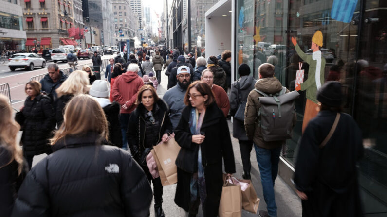 Un grupo de personas pasea por un lujoso distrito comercial de Manhattan el 5 de diciembre de 2022 en Nueva York (EE.UU.). (Spencer Platt/Getty Images)