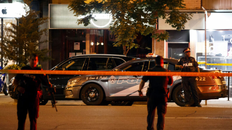 Agentes de la Policía de Toronto caminan por la escena de crimen en la calle Danforth en Toronto, Ontario, Canadá, el 23 de julio de 2018. (Cole Burson/AFP vía Getty Images)