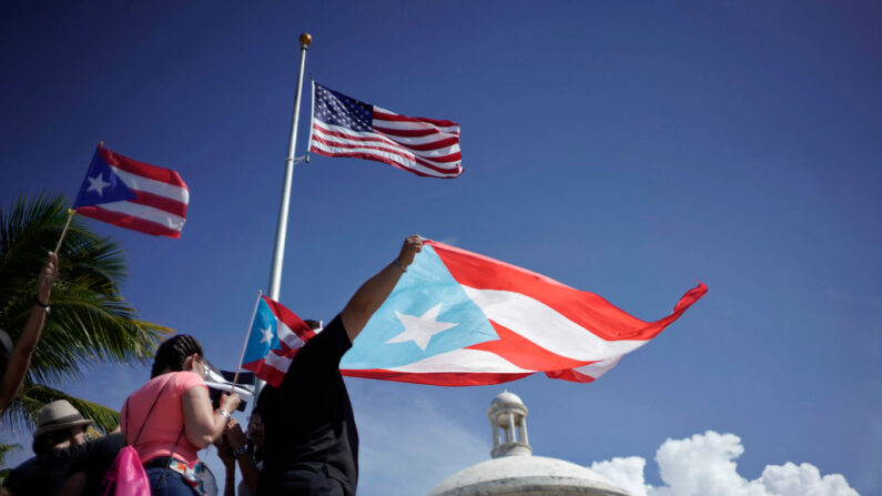 Personas sostienen banderas de Puerto Rico en San Juan, Puerto Rico, el 17 de julio de 2019. (ERIC ROJAS/AFP vía Getty Images)