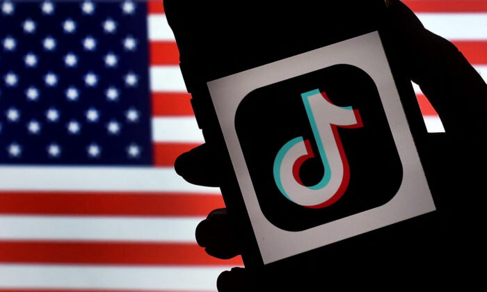 El logotipo de la aplicación de redes sociales TikTok en la pantalla de un iPhone sobre un fondo de bandera estadounidense, en Arlington, Virginia, el 3 de agosto de 2020. (Olivier Douliery/AFP vía Getty Images)