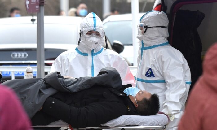 Trabajadores médicos llevan a un paciente a una clínica para tratar la fiebre, en Beijing, el 13 de enero de 2021. (Greg Baker/AFP vía Getty Images)
