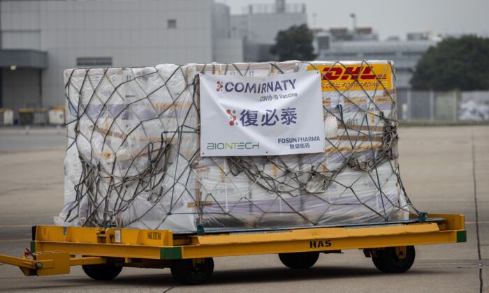 Un carro con cajas de la vacuna contra el COVID-19 de Pfizer-BioNTech se transporta a un almacén después de ser descargado de un avión de carga de Cathay Pacific en el Aeropuerto Internacional de Hong Kong, el 27 de febrero de 2021. (Jerome Favre/POOL/AFP vía Getty Images)
