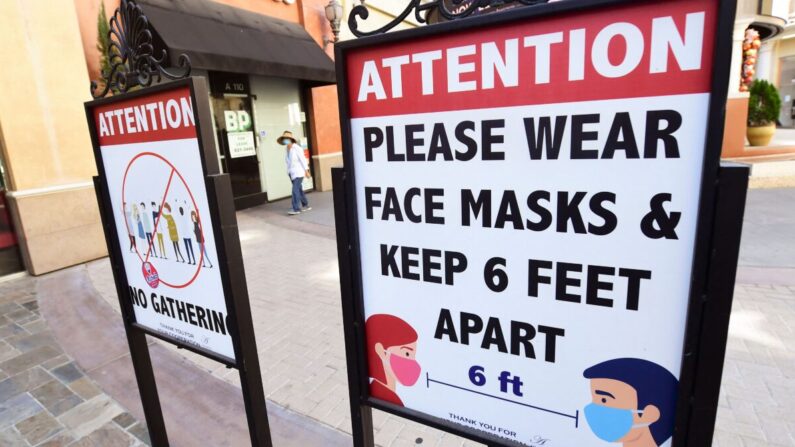 Carteles que recuerdan el distanciamiento social y el uso de mascarillas permanecen en un centro comercial de California el 14 de junio de 2021. (Frederic J. Brown/AFP vía Getty Images)
