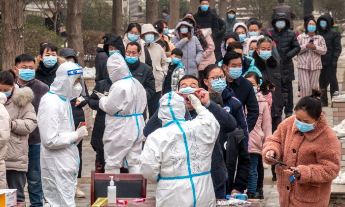 Los residentes hacen cola para someterse a las pruebas de ácido nucleico para detectar COVID-19 en Anyang en la provincia central china de Henan el 26 de enero de 2022. (STR/AFP vía Getty Images)