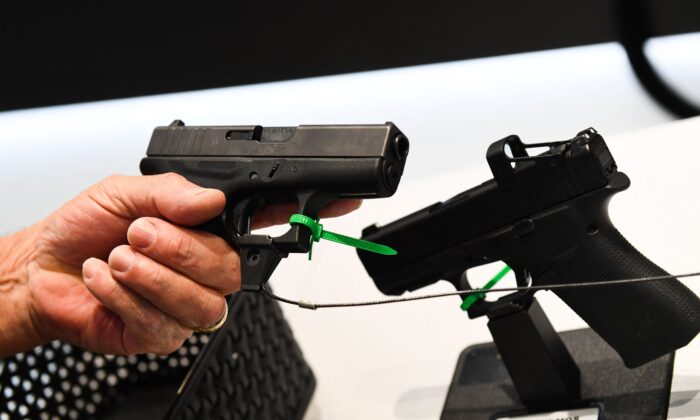 Un asistente sostiene una pistola Glock Ges.mbH durante la reunión anual de la Asociación Nacional del Rifle (NRA), en el Centro de Convenciones George R. Brown, en Houston, Texas, el 28 de mayo de 2022. (Patrick T. Fallon/AFP/Getty Images)
