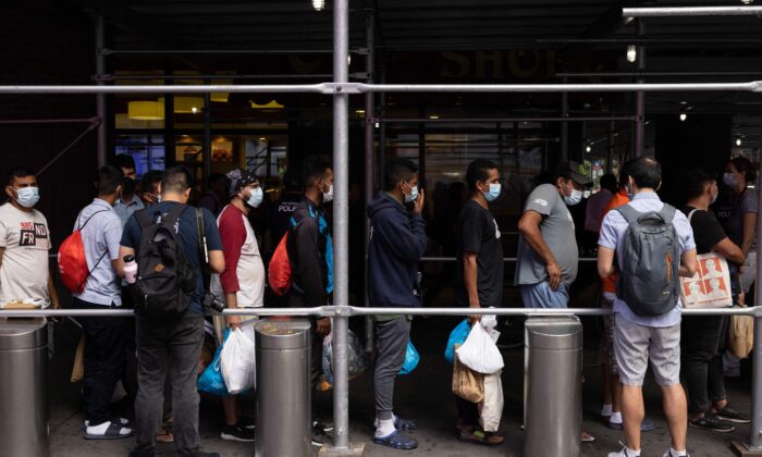 Un grupo de migrantes de Texas espera en la cola ante la terminal de autobuses Port Authority para recibir ayuda humanitaria en Nueva York el 10 d agosto de 2022. (Yuki Iwamura/AFP vía Getty Images)