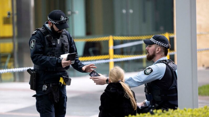 En una fotografía de archivo, la policía habla con un testigo después de que un hombre armado abriera fuego en el aeropuerto de Canberra (Australia) el 14 de agosto de 2022. (STR/AFP vía Getty Images)
