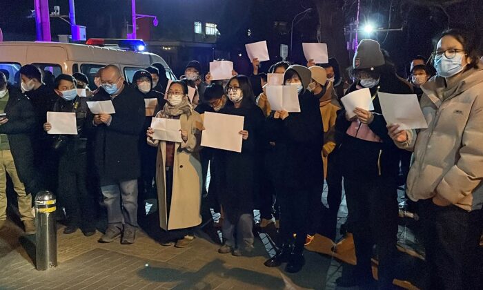 Manifestantes se reúnen a lo largo de una calle durante una manifestación por las víctimas de un incendio mortal y contra los duros confinamientos en China por el COVID-19, en Beijing, el 28 de noviembre de 2022. (Michael Zhang/AFP vía Getty Images)