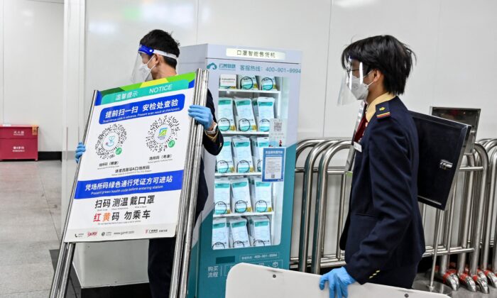 Un miembro del personal del metro retira un cartel del código sanitario COVID-19 utilizado al entrar en el metro de Guangzhou, en la provincia meridional china de Guangdong, tras la relajación de las restricciones de COVID-19 en la ciudad, el 7 de diciembre de 2022. (CNS/AFP vía Getty Images)