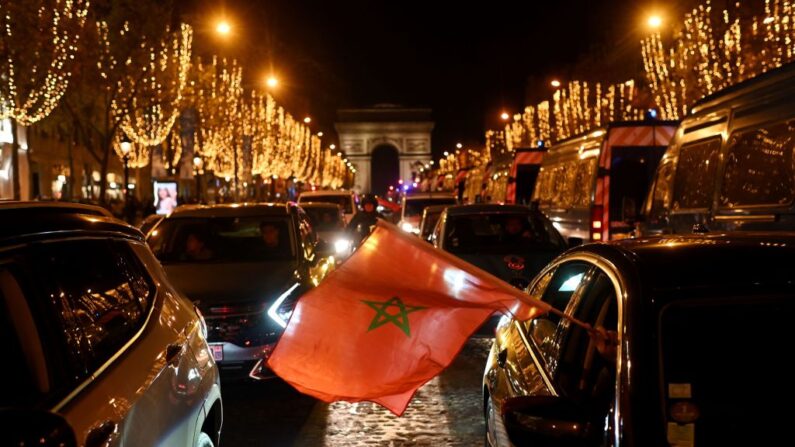 Una persona ondea una bandera nacional marroquí desde un coche por la avenida de los Campos Elíseos en París (Francia) el 10 de diciembre de 2022, mientras la gente celebra la victoria de Marruecos en el partido de fútbol de cuartos de final de la Copa del Mundo Qatar 2022 contra Portugal. (Martin Bureau/AFP vía Getty Images)