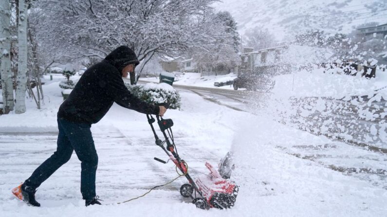 Un hombre limpia la nieve de la entrada de su casa tras una tormenta nocturna en Provo, Utah (EE.UU.), el 13 de diciembre de 2022. (George Frey/AFP vía Getty Images)