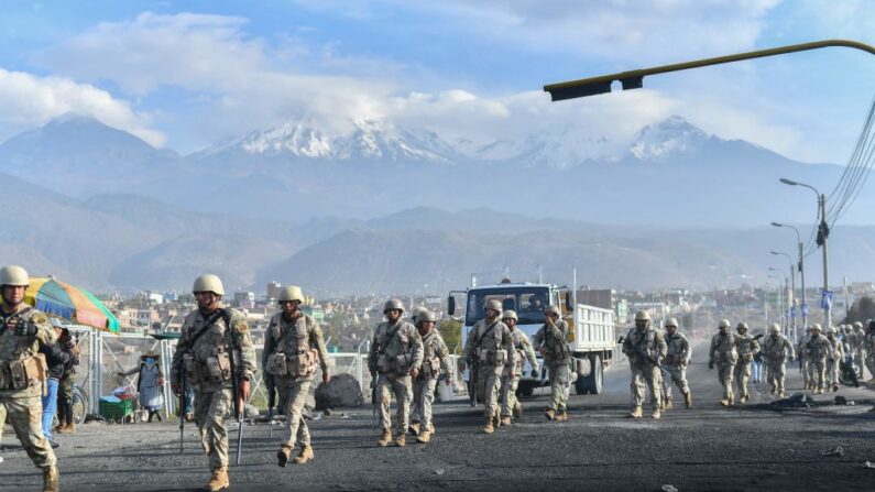 Soldados se preparan para limpiar los escombros dejados por los alborotadores de la carretera Arequipa-Puno en el puente Añashuayco en Arequipa, Perú, el 15 de diciembre de 2022, tras la declaración del estado de emergencia nacional. (Diego Ramos/AFP vía Getty Images)