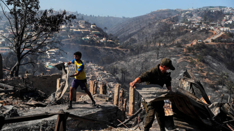 Hombres retiran escombros de casas destruidas por un incendio forestal en los cerros de Viña del Mar, en la región de Valparaíso, Chile, el 23 de diciembre de 2022. (Javier Torres/AFP vía Getty Images)