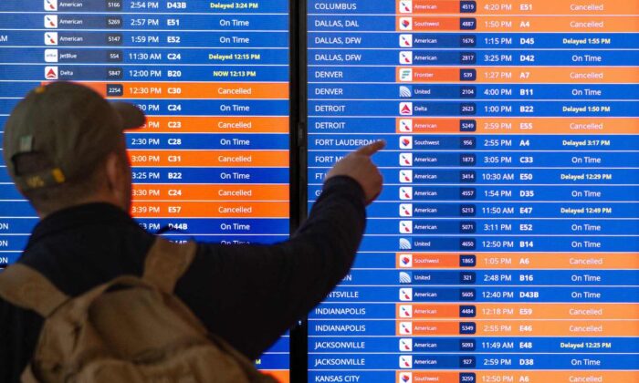 Un viajero mira un tablero de información que muestra cancelaciones y retrasos de vuelos en el aeropuerto Reagan National durante una tormenta de invierno antes de las vacaciones de Navidad en Arlington, Virginia, el 23 de diciembre de 2022. (Mandel Ngan/AFP vía Getty Images)