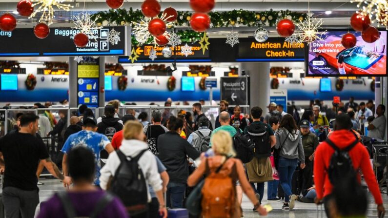 Viajeros caminan por el Aeropuerto Internacional de Miami durante una tormenta invernal antes de las vacaciones de Navidad en Miami, Florida, el 23 de diciembre de 2022. (CHANDAN KHANNA/AFP vía Getty Images)