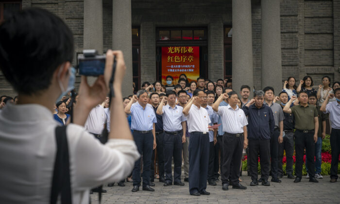 Visitantes prestan juramento frente a una bandera comunista (no se ve) en la entrada del Edificio Rojo de la Universidad de Beijing, en Beijing, el 30 de junio de 2021. (Andrea Verdelli/Getty Images)