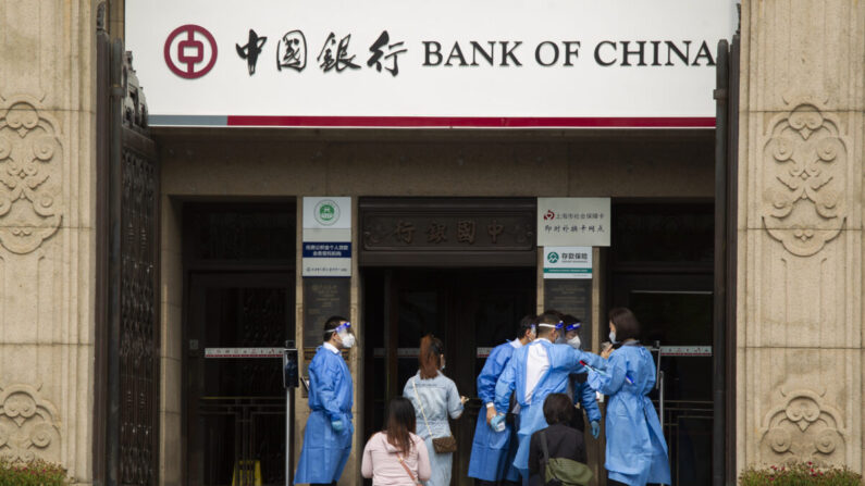 El personal entra en un banco en la zona histórica del Bund el 01 de junio 2022 en Shanghái, China. (Hu Chengwei/Getty Images)