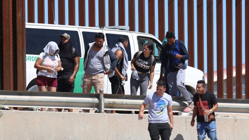 Ciudadanos venezolanos caminan a lo largo de la valla fronteriza hacia una camioneta de la Patrulla Fronteriza que los espera después de cruzar ilegalmente el Río Grande desde México, en El Paso, Texas, el 21 de septiembre de 2022. (Joe Raedle/Getty Images)