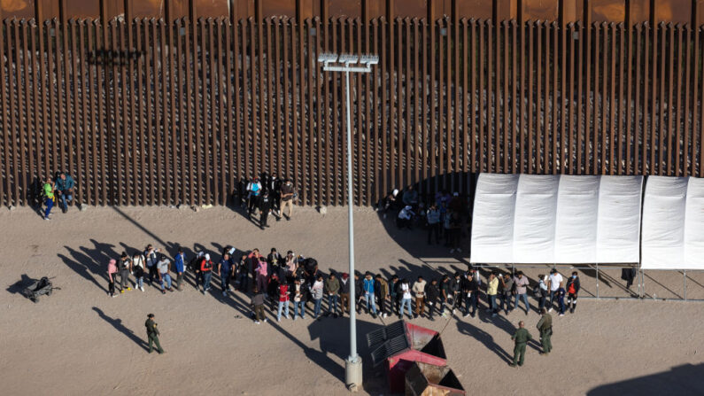 Inmigrantes esperan ser procesados por agentes de la Patrulla Fronteriza estadounidense mientras solicitan asilo en Estados Unidos el 28 de septiembre de 2022 cerca de Yuma, Arizona (EE.UU.). (John Moore/Getty Images)