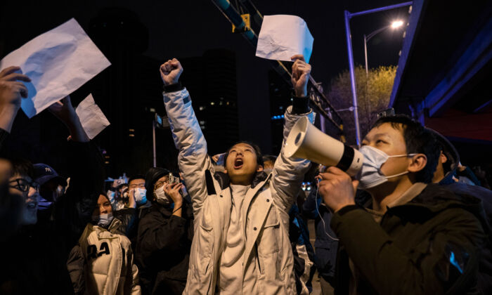 Los manifestantes gritan consignas durante una protesta contra las estrictas medidas de reducción a cero COVID de China en Beijing, el 28 de noviembre de 2022. (Kevin Frayer/Getty Images)