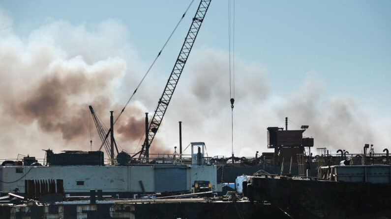 El humo sale de un edificio mientras los bomberos y otro personal de emergencia trabajan para controlar un gran incendio en el barrio de Red Hook en Brooklyn el 13 de diciembre de 2022 en la ciudad de Nueva York. (Spencer Platt/Getty Images)