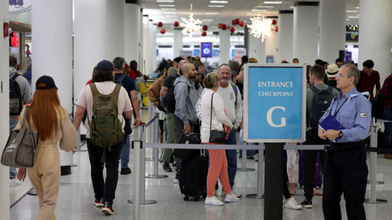 Viajeros hacen cola en un puesto de control de la TSA en el Aeropuerto Internacional de Miami el 19 de diciembre de 2022 en Miami, Florida. (Joe Raedle/Getty Images)