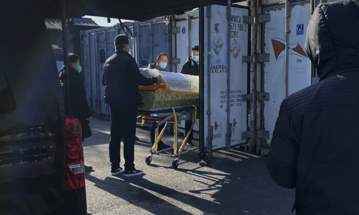 Se carga un ataúd desde un coche fúnebre a un contenedor de almacenamiento en el crematorio y funeraria de Dongjiao, uno de varios en la ciudad que gestiona casos de COVID-19 en Beijing, China, el 18 de diciembre de 2022. (Getty Images)