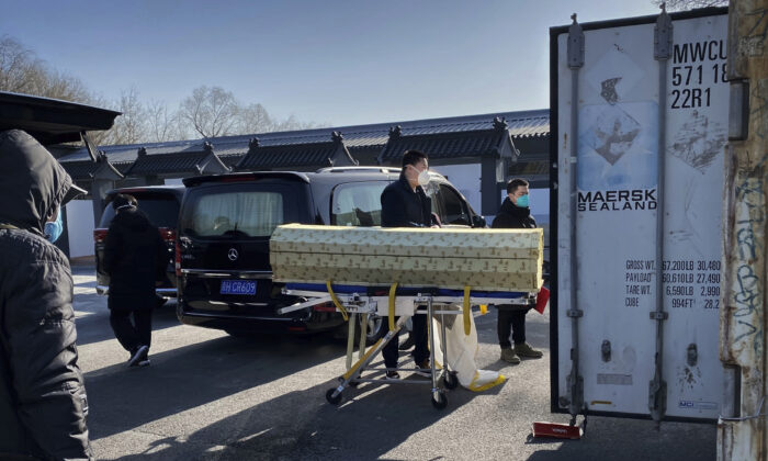 Un ataúd es cargado desde un coche fúnebre a un contenedor de almacenamiento en el crematorio y funeraria Dongjiao, uno de los varios de la ciudad que se ocupa de los casos de COVID-19, en Beijing el 18 de diciembre de 2022. (Getty Images)